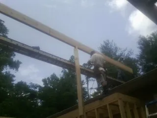 Carpenter setting a ridge beam over a new addition frame — Ice Dam Removal by Roofing Brothers in Normandy