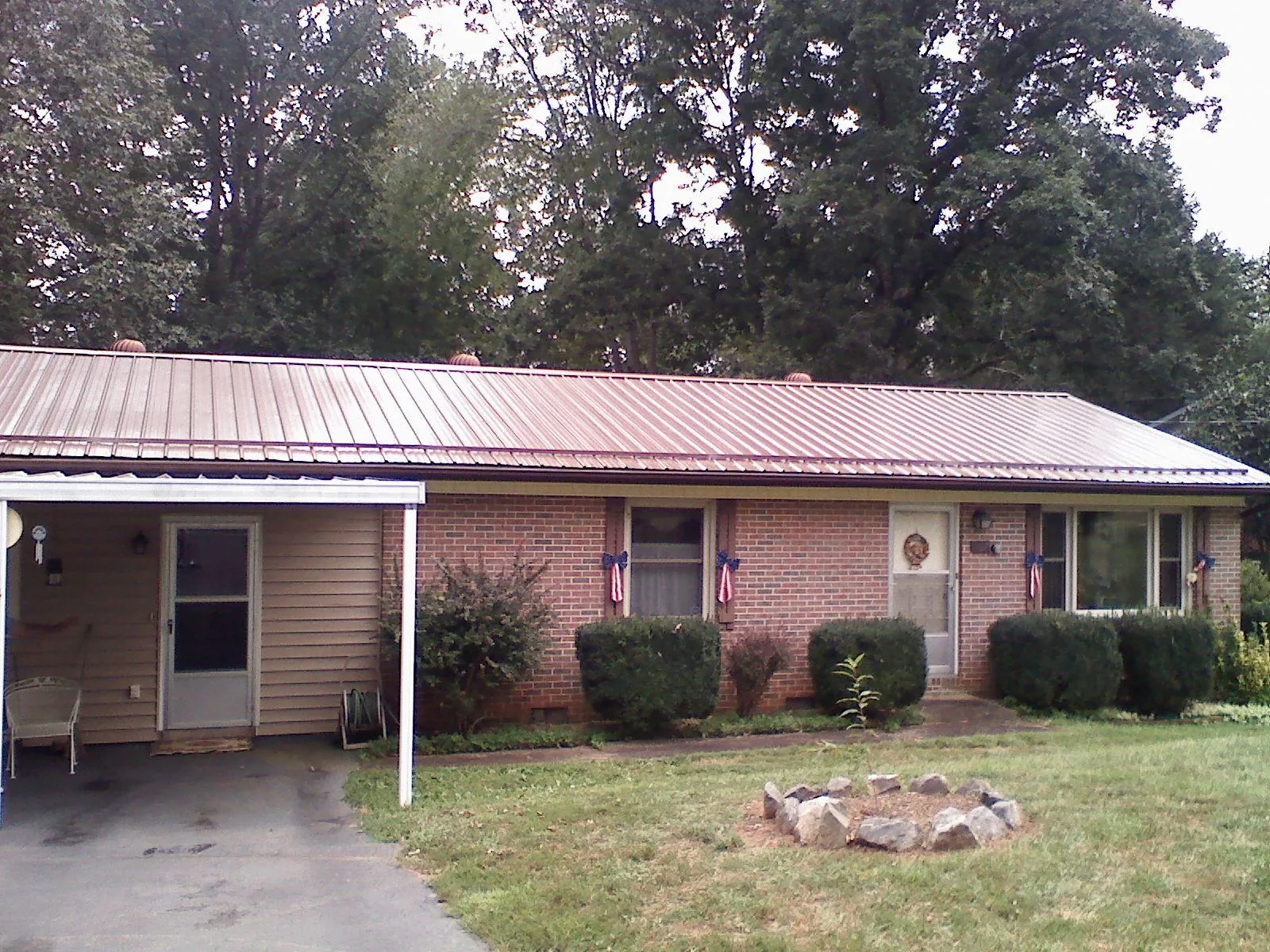 Bronze metal roof and carport on a brick ranch home — Roof Repair work by our crew in Normandy